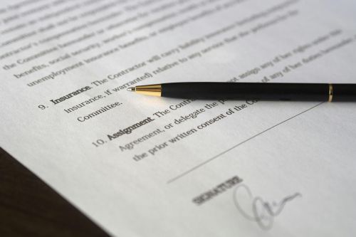 Close-up image of a business contract and pen, signed and ready for agreement.