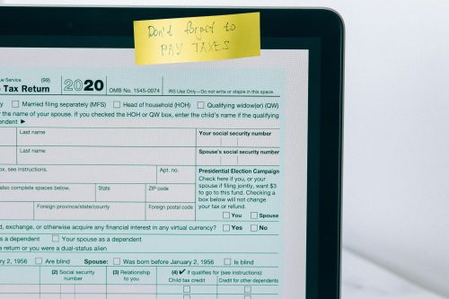 Laptop showing tax form with a reminder note, emphasizing tax payment.